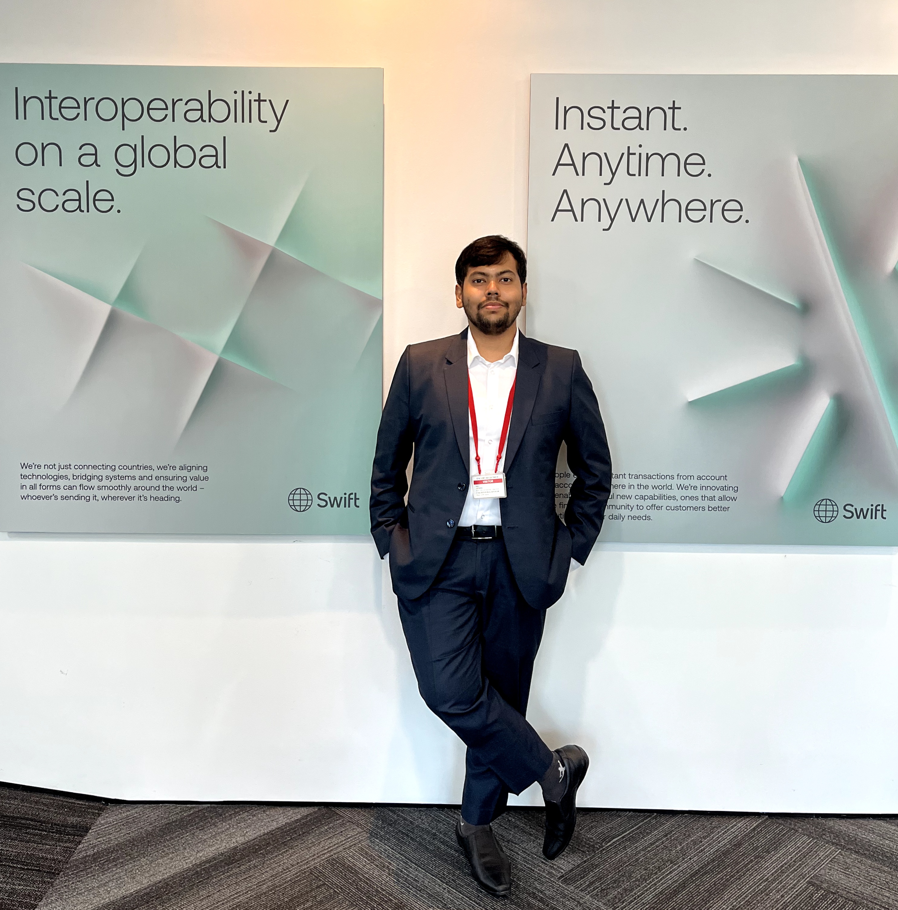 Sakir Ahmed at a SWIFT international conference, standing in front of SWIFT branding